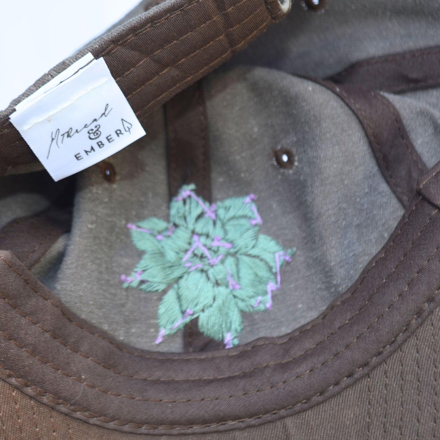 Interior view of handcrafted succulent embroidery on the brown baseball hat.