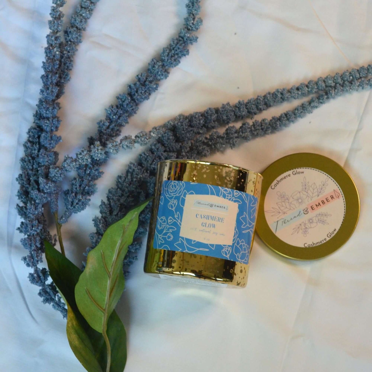 Thread & Ember Cashmere Glow candle styled with lavender sprigs and eucalyptus.