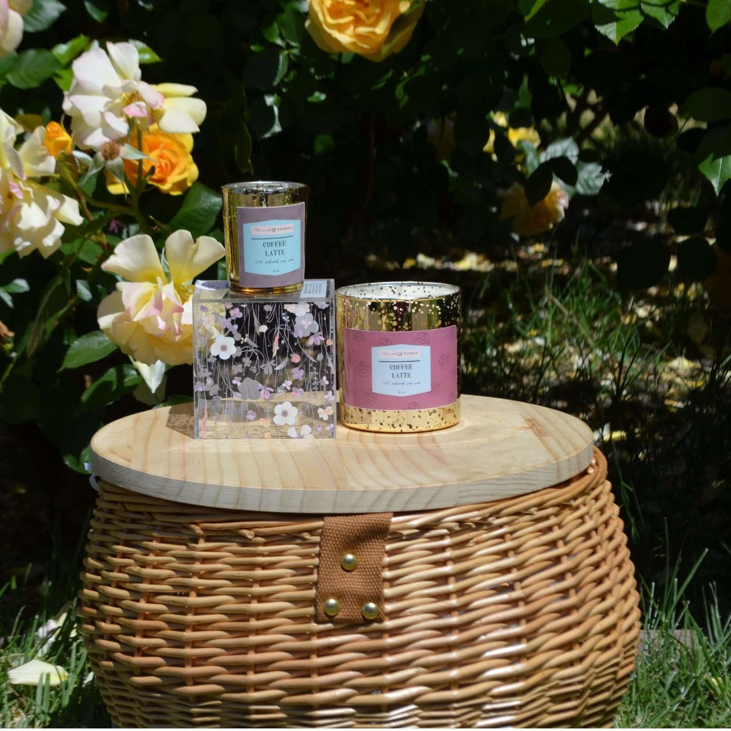 Coffee Latte scented candles displayed outdoors with fresh roses.