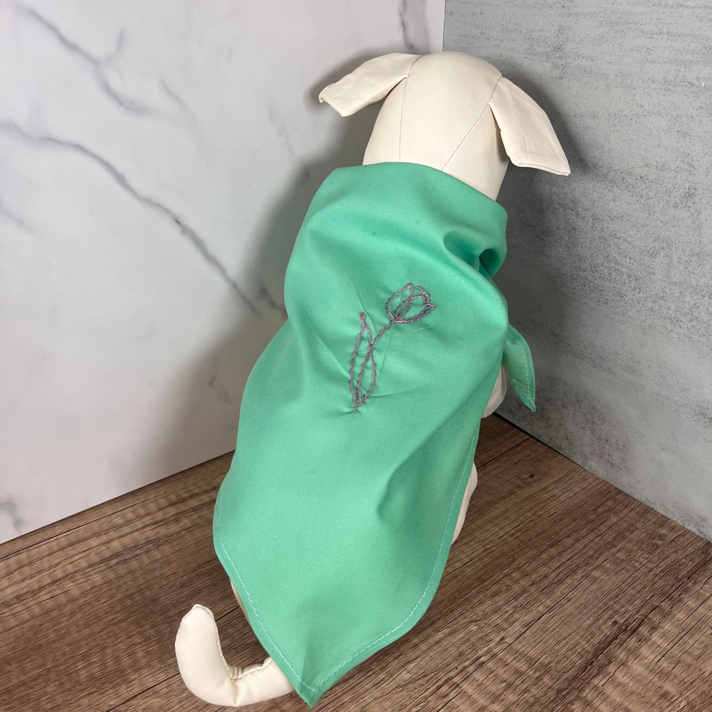 Green cotton pet bandana with pink tulip embroidery, modeled on a dog, showcasing the lightweight and comfortable fit.