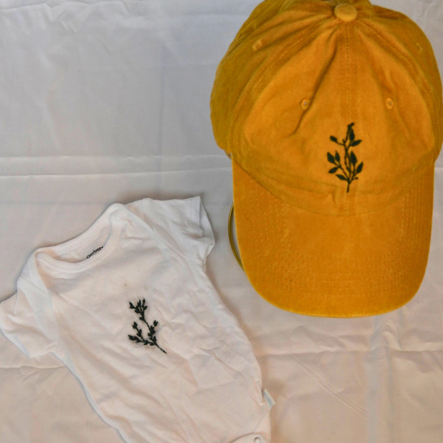 Soft baby onesie featuring greenery embroidery, perfect for newborns and baby gifts.