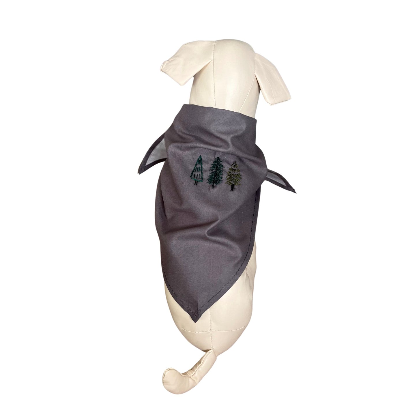Gray cotton pet bandana with hand-embroidered evergreen tree design, modeled on a dog against a clean background.