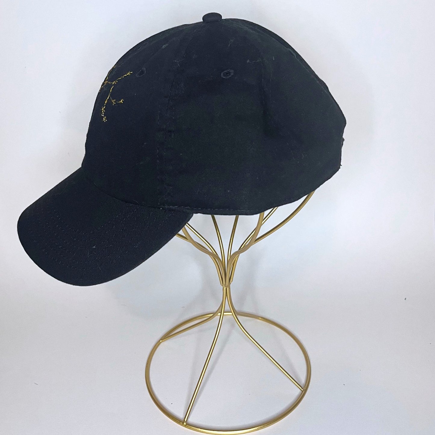 Left-side profile of the black Sagittarius constellation hat, highlighting its curved brim and adjustable strap.