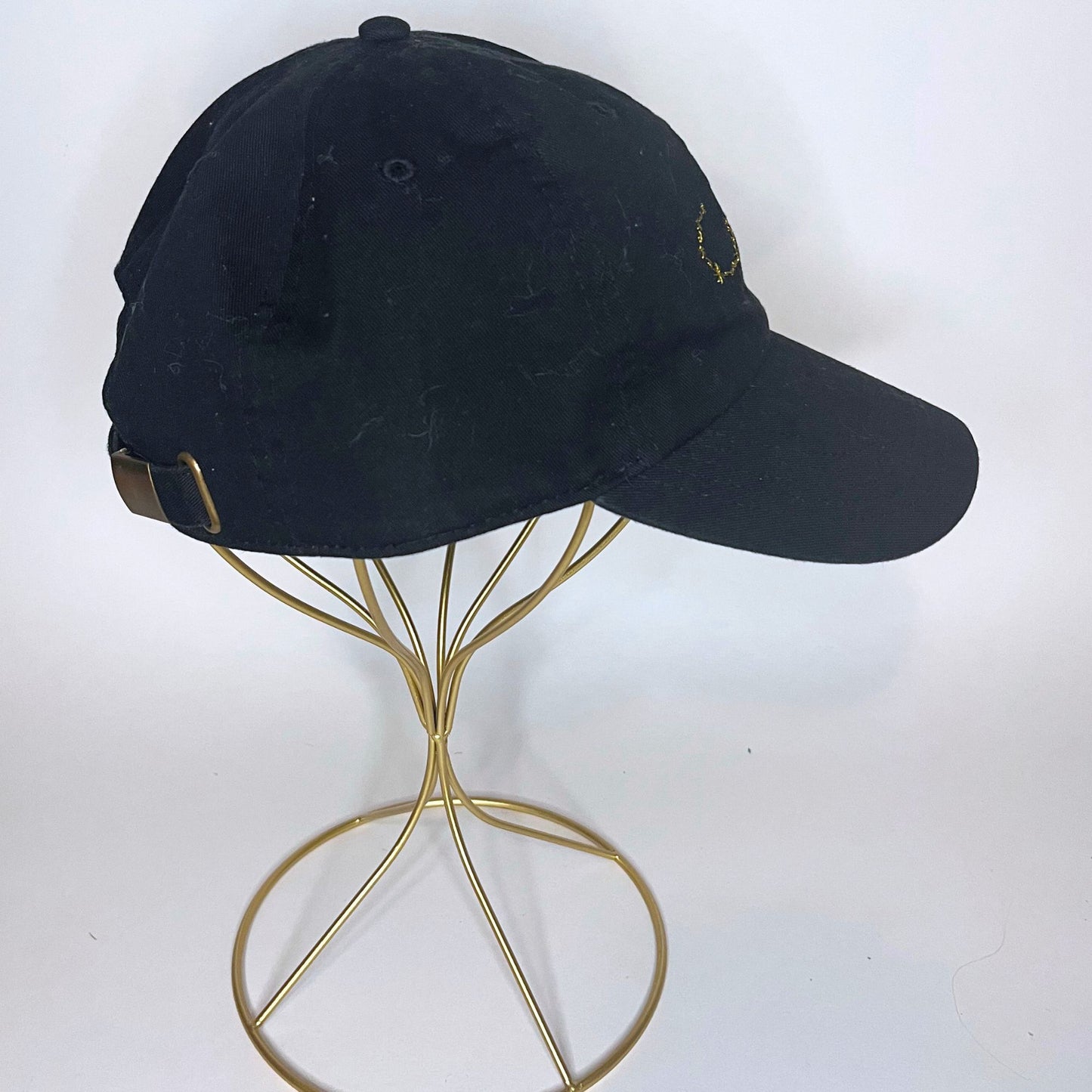 Right side view of a black Scorpio zodiac constellation hat with adjustable strap and brass buckle.