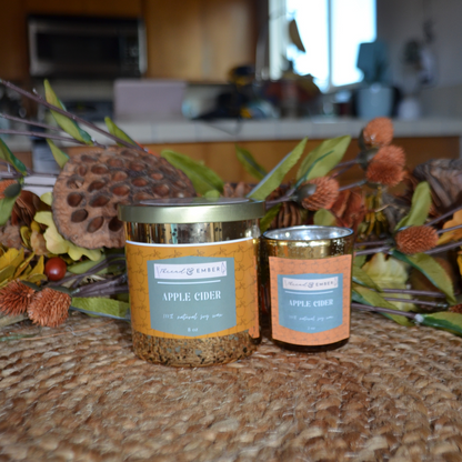 Thread & Ember Apple Cider Candle available in two sizes, displayed with seasonal decor on a natural woven surface.