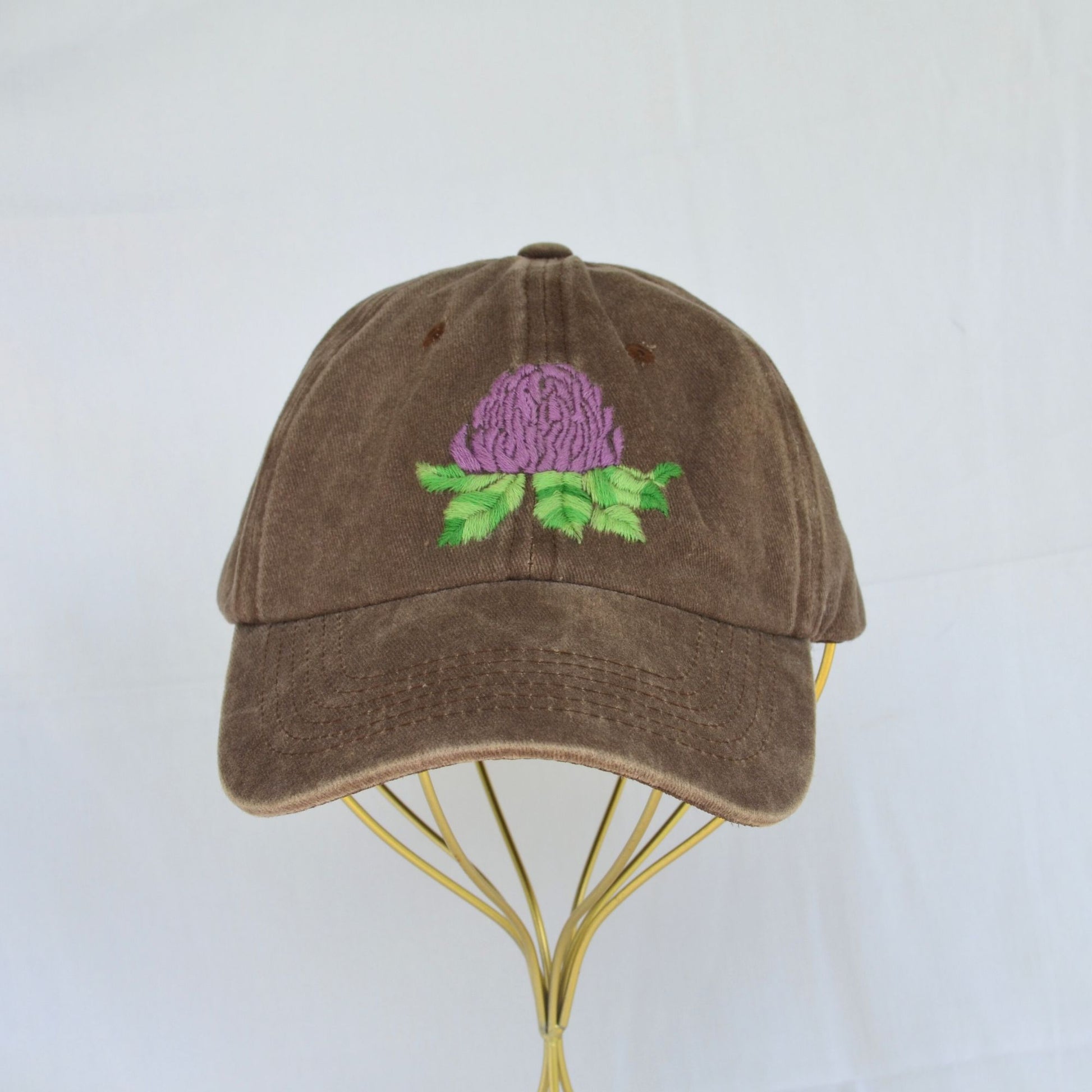 Top-front view of a brown baseball hat with vibrant artichoke embroidery.