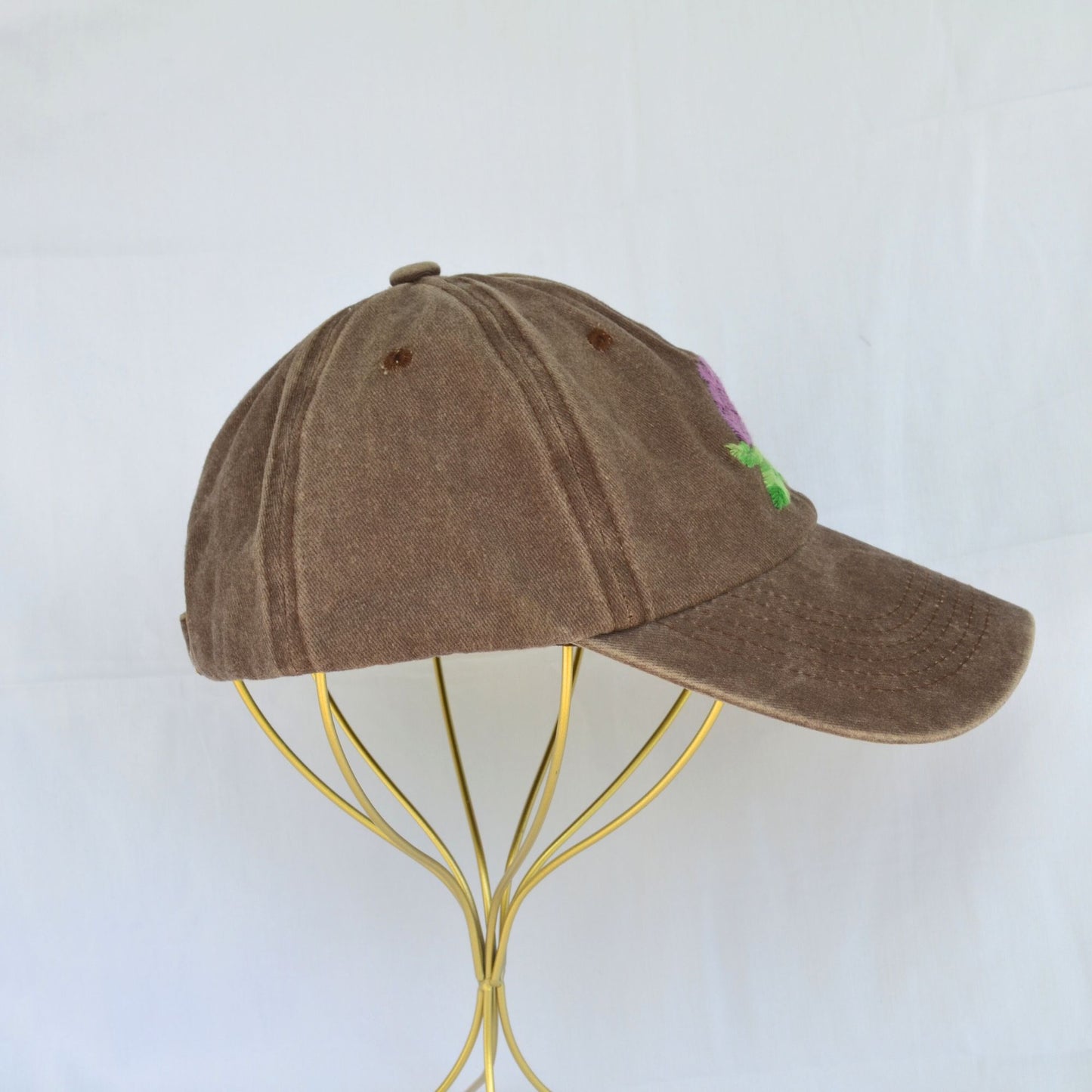 Right side view of a brown baseball hat with artichoke embroidery.